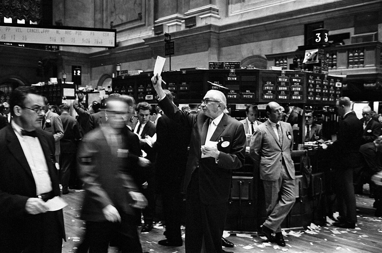 Traders crowd the floor of the New York Stock Exchange in a black-and-white photo from the 1960s